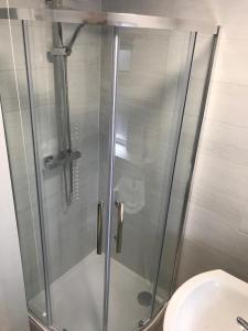 a shower with a glass door next to a toilet at Cozy Snowdonia Chalet in Caernarfon