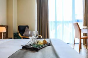 una habitación de hotel con una bandeja de comida y copas de vino en Aurora Serviced Apartments, en Ho Chi Minh