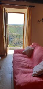 a bed in a room with a large window at La Petite Maison des Artistes in Castelnau-Pégayrols