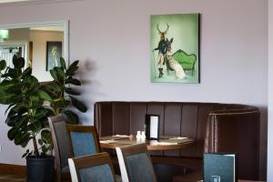 a dining room with a table and chairs and a plant at Kinloch Hotel, Isle of Arran in Blackwaterfoot