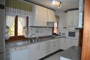Una cocina con gabinetes blancos y un fregadero y una ventana. en Casa Santo Tomé, en Toledo