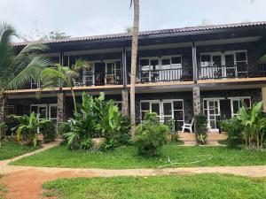 a house with a palm tree in front of it at Thong Nai Pan Beach Residence in Thong Nai Pan Yai