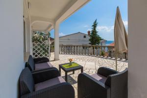 a patio with chairs and a table and an umbrella at Apartments Slavica in Dramalj