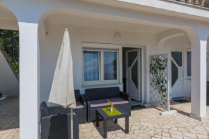 a patio with a table and a umbrella at Apartments Slavica in Dramalj