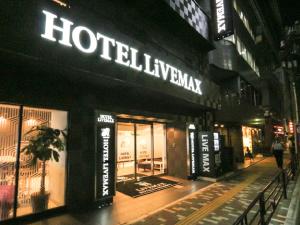 a building with a hotel luxurymark sign on it at night at HOTEL LiVEMAX Ueno-Ekimae in Tokyo