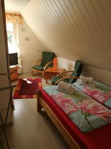 ein Schlafzimmer mit einem Bett und Stühlen im Dachgeschoss in der Unterkunft FerienWohnung Gebhardt in Binz