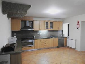 a kitchen with wooden cabinets and stainless steel appliances at Casa da Aldeia MGS in Laundos