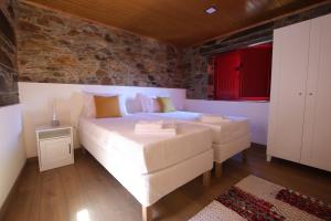 a bedroom with a large bed and a brick wall at Casa do Ocreza in Sobral Fernando