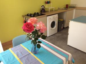 un jarrón de flores sobre una mesa en una cocina en Gite de Cerisier, en Saint-Nicolas-de-la-Grave