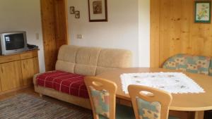 een woonkamer met een tafel en een bank bij Ferienwohnung Schmiedbauer in Gosau
