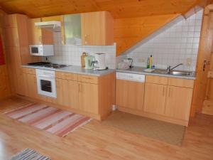een keuken met houten kasten en een spoelbak bij Ferienwohnung Schmiedbauer in Gosau