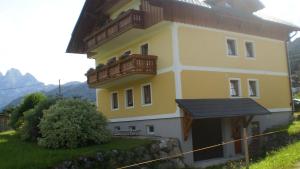 een geel huis met balkons erop bij Ferienwohnung Schmiedbauer in Gosau +9 foto's