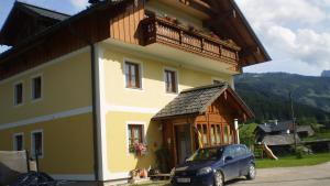 een huis met een auto ervoor geparkeerd bij Ferienwohnung Schmiedbauer in Gosau