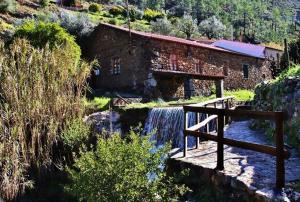 a bridge over a stream in front of a building at Casa do Ocreza in Sobral Fernando