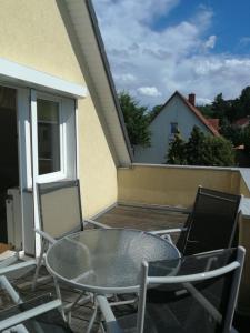 ein Glastisch und Stühle auf einem Balkon in der Unterkunft FerienWohnung Gebhardt in Binz