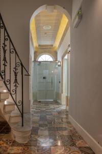 um corredor com uma porta de vidro e um piso de azulejo em Chapter 5 Hotel em Taʼ Xbiex