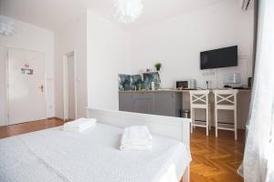 Habitación blanca con cama y cocina en Oberiter Apartments - in the heart of Zagreb en Zagreb