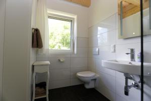 ein Bad mit einem Waschbecken, einem WC und einem Fenster in der Unterkunft Ferienwohnungen Unterleegut in Mühlbach am Hochkönig