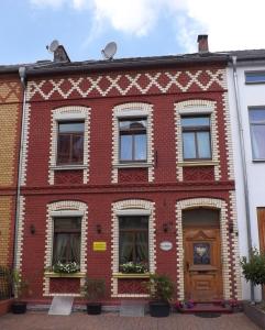 ein rotes Backsteingebäude mit Fenstern und einer Tür in der Unterkunft Boardinghouse Castell in Bonn