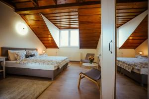 two beds in a room with wooden ceilings at Sobe "Majerling" in Majerje