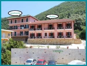 a large pink building with cars parked in front of it at Liotrivi Studios in Vasiliki