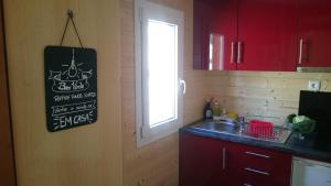a kitchen with red cabinets and a sink and a window at Casa DiMaria in Trancoso