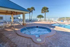 een hot tub in een patio naast een zwembad bij Townhouse at San Remo in Clearwater Beach