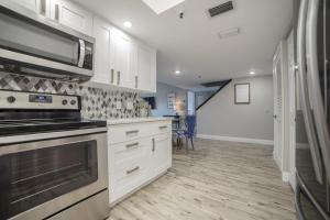 een keuken met witte kasten en een kookplaat oven bij Townhouse at San Remo in Clearwater Beach