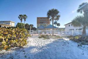 een strand met een hek, palmbomen en een gebouw bij Townhouse at San Remo in Clearwater Beach