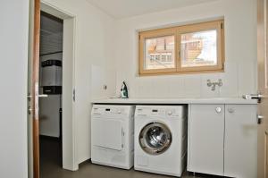 a white laundry room with a washer and dryer at Chalet Rothenegg - GRIWA RENT AG in Grindelwald
