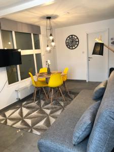 uma sala de estar com um sofá, uma mesa e cadeiras em Apartment Park em Osijek