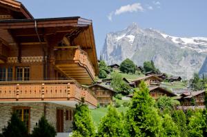 um edifício com uma montanha ao fundo em Chalet Rothenegg - GRIWA RENT AG em Grindelwald