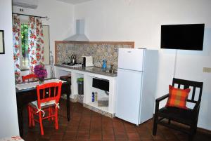 uma cozinha com um frigorífico branco, uma mesa e cadeiras em B&B Terre Di Sicilia em Giardini Naxos