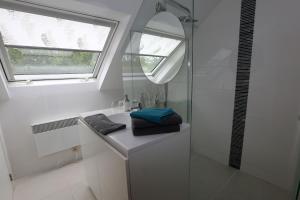 a bathroom with a sink and a shower with a window at B&B Le Bois de Champia in Huy