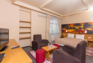 a hotel room with a bed and chairs and a television at Hotel Lirak in Tetovo