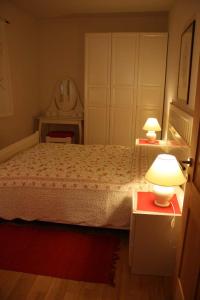 1 dormitorio con 1 cama con 2 lámparas y espejo en Haus Rogger, en Caldaro
