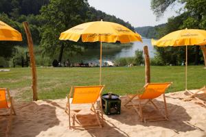 a group of chairs and umbrellas in the sand at Waldkiez Tiefensee in Tiefensee