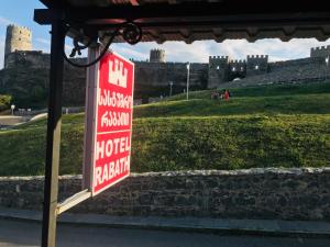 un cartello per un hotel con un castello sullo sfondo di Hotel Rabath a Akhaltsikhe