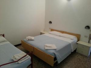 two beds in a small room with towels on them at Fiorina Bed&Breakfast - Colazione fino a mezzogiorno - Beach Village gratuito in Riccione