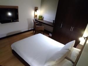 a bedroom with a bed and a desk and a television at Scala 68 in Bogotá