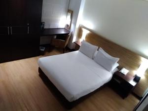 a bedroom with a large white bed and a desk at Scala 68 in Bogotá +32 photos