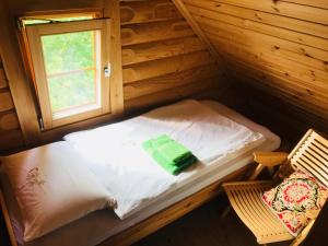 a small bed in a cabin with a window at Romantic Cottage House in Žužemberk