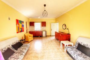 a living room with two couches and a kitchen at Avra Sunset Sea View Liapades in Liapades