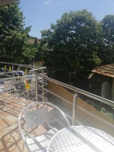 a deck with a table and chairs on a balcony at Къща Мариела in Sinemorets