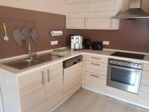 a kitchen with white cabinets and a sink and a stove at Fewo Monika Mayr in Pfronten