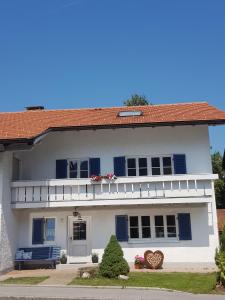 a white house with blue shutters at Fewo Monika Mayr in Pfronten