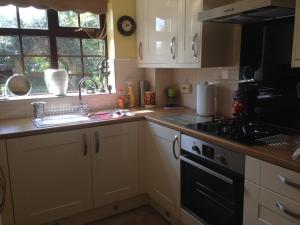 a kitchen with a sink and a stove top oven at Jen's Friendly Place in Dudley