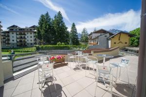 um pátio com cadeiras e mesas numa varanda em Residence Tabor em Bardonecchia