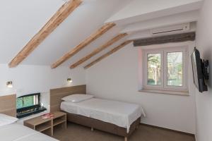 - une chambre avec 2 lits et une fenêtre dans l'établissement Hotel Vimbula - Komolac, à Mokošica