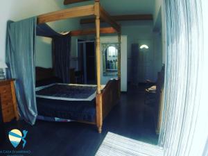 a bedroom with a canopy bed with a mirror at A Casa di Mariano in Alata